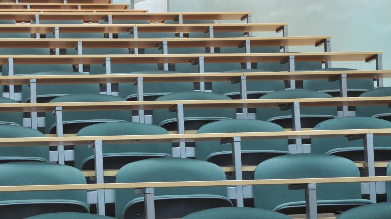 Rows of empty desks in a lecture hall